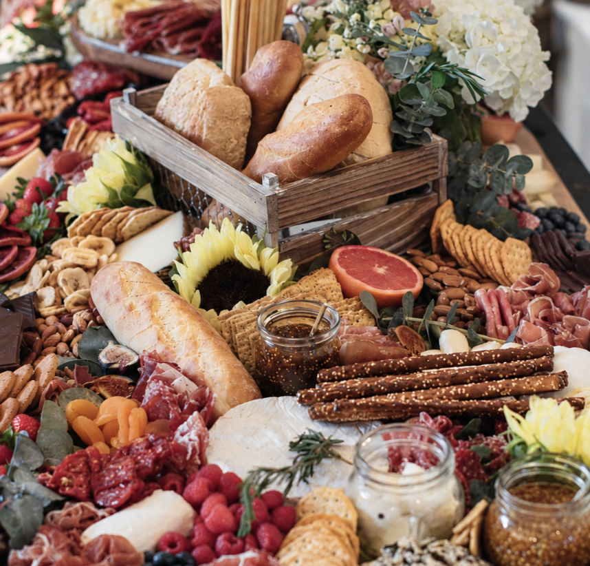 Beautifully presented catering grazing table with breads, charcuterie, fruit and accompaniments